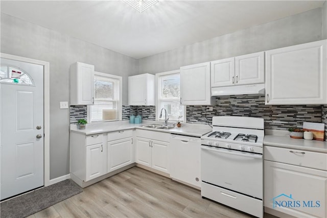 kitchen with light countertops, a sink, light wood-type flooring, white appliances, and under cabinet range hood