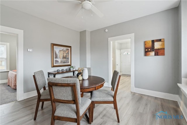 dining room with light wood-type flooring, a ceiling fan, and baseboards