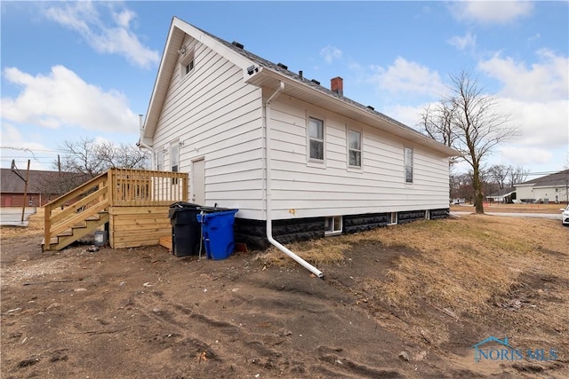 view of side of property featuring stairs and a chimney