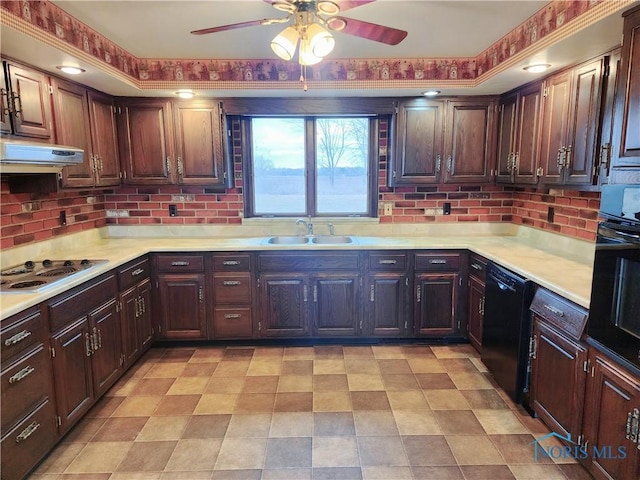 kitchen with black appliances, backsplash, a sink, and light countertops