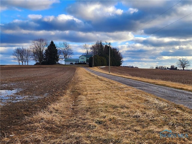 view of street featuring a rural view and gravel driveway