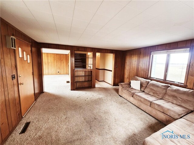 3221 Carrell Rd, Bucyrus, OH 44820 - unfurnished living room with carpet and wood walls