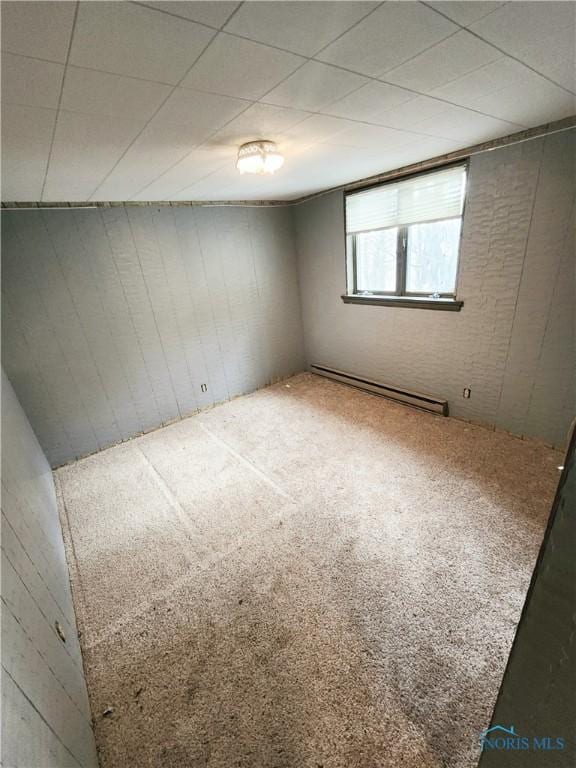 empty room with carpet floors and a baseboard heating unit