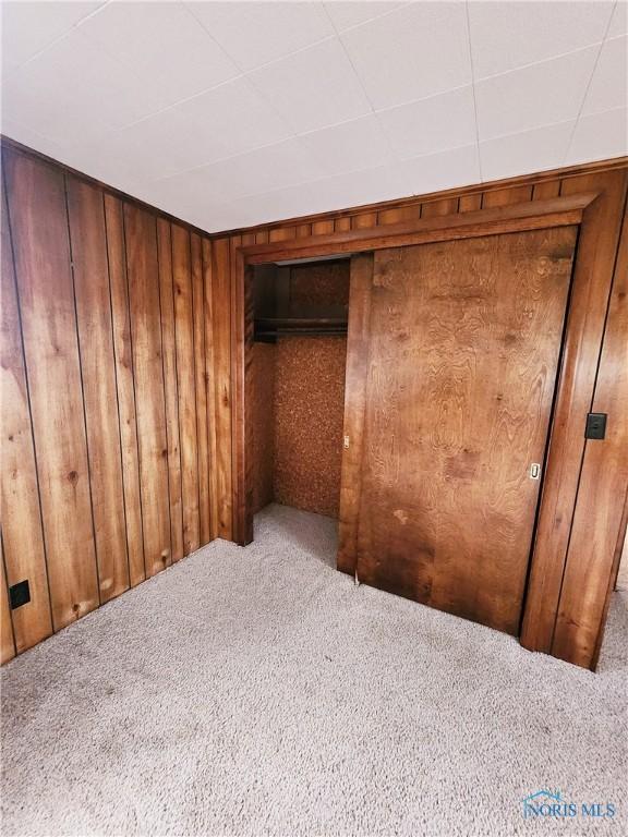 3221 Carrell Rd, Bucyrus, OH 44820 - unfurnished bedroom with carpet floors and wooden walls