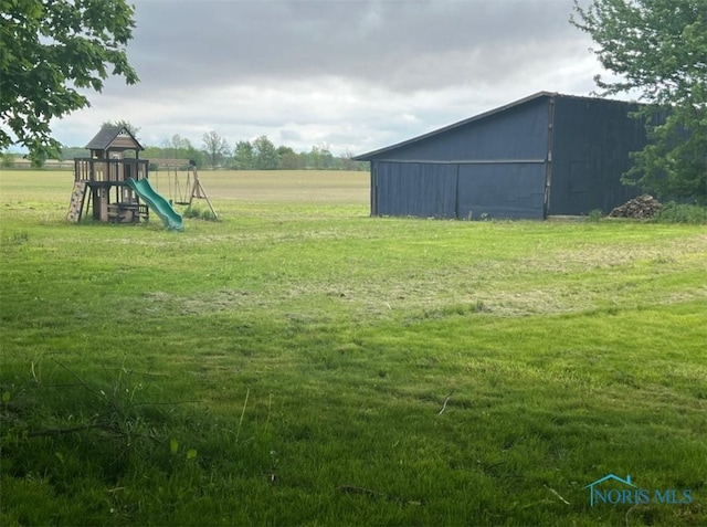 3221 Carrell Rd, Bucyrus, OH 44820 - view of grassy yard with a playground, an outbuilding, and a pole building