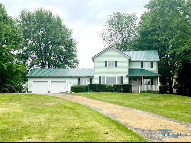 3221 Carrell Rd, Bucyrus, OH 44820 - traditional home featuring asphalt driveway, a front lawn, a porch, an attached garage, and metal roof