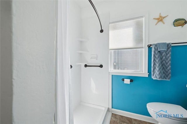 full bath with toilet, baseboards, and walk in shower