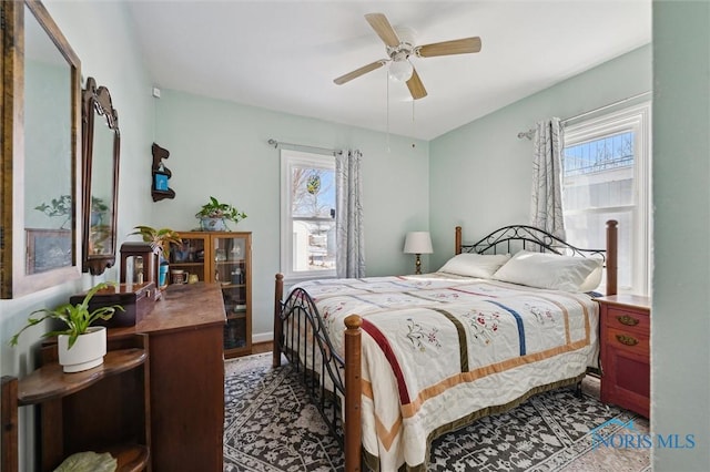 bedroom with a ceiling fan and multiple windows