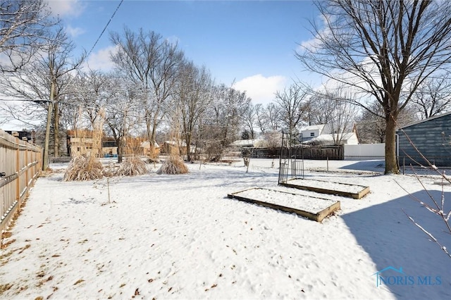 snowy yard featuring fence