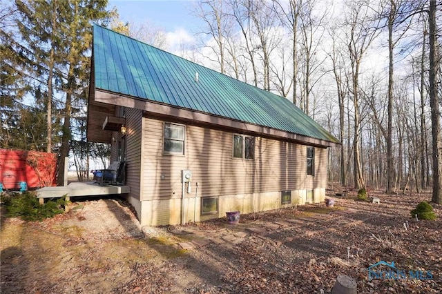 view of side of property featuring a deck and metal roof