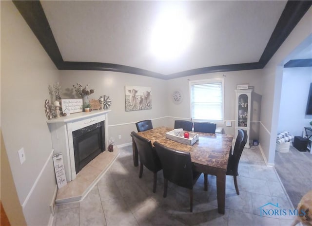 dining room with light tile patterned floors, a premium fireplace, and baseboards