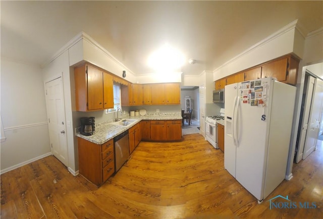 kitchen with crown molding, stainless steel appliances, brown cabinetry, a sink, and wood finished floors