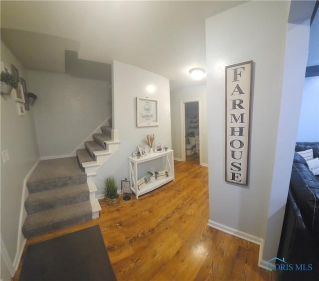 interior space with stairs, baseboards, and wood finished floors