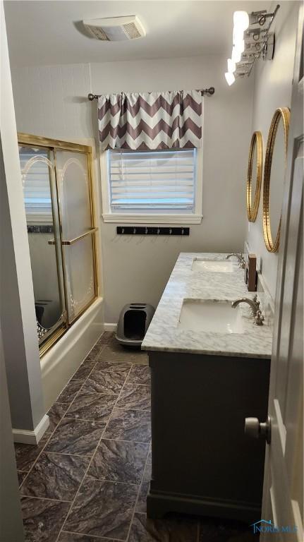 full bathroom featuring marble finish floor, visible vents, shower / bath combination with glass door, and vanity