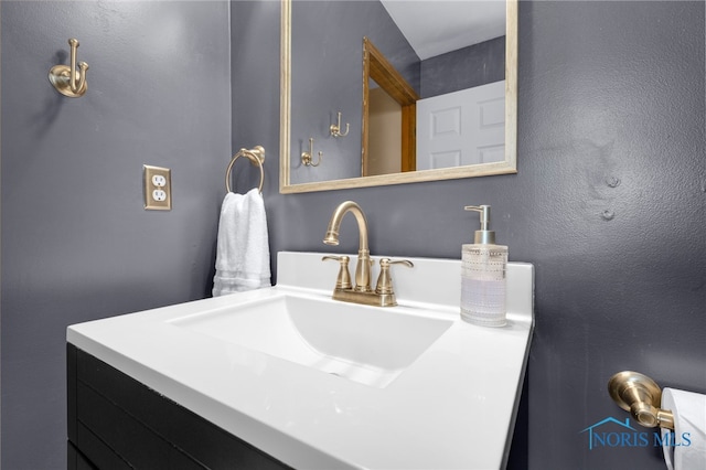 bathroom with a textured wall and vanity