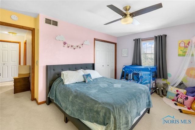 bedroom with baseboards, visible vents, light colored carpet, ceiling fan, and a closet