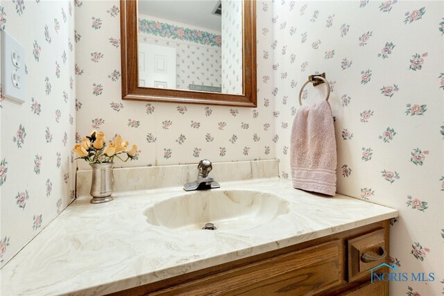 bathroom featuring vanity and wallpapered walls