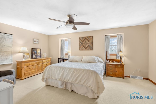 bedroom featuring light colored carpet, visible vents, ceiling fan, and baseboards