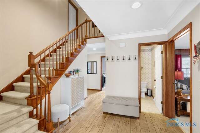 interior space featuring stairs, ornamental molding, and wood-type flooring