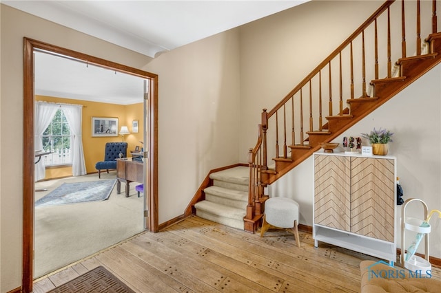 stairway featuring wood-type flooring and baseboards