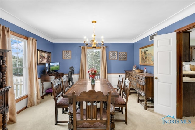 dining space with a chandelier, ornamental molding, visible vents, and light colored carpet