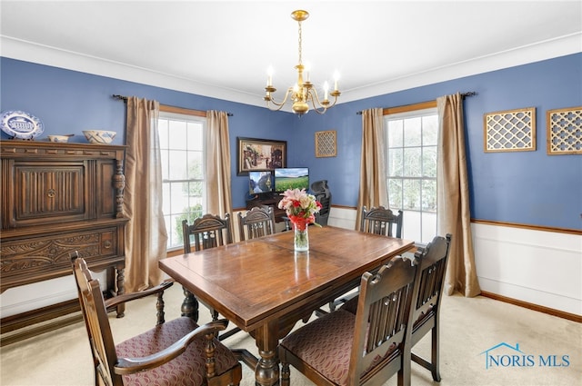 dining area featuring a wainscoted wall, plenty of natural light, a chandelier, and light colored carpet