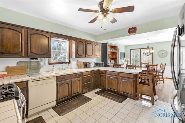 kitchen with a peninsula, plenty of natural light, stainless steel appliances, and a sink