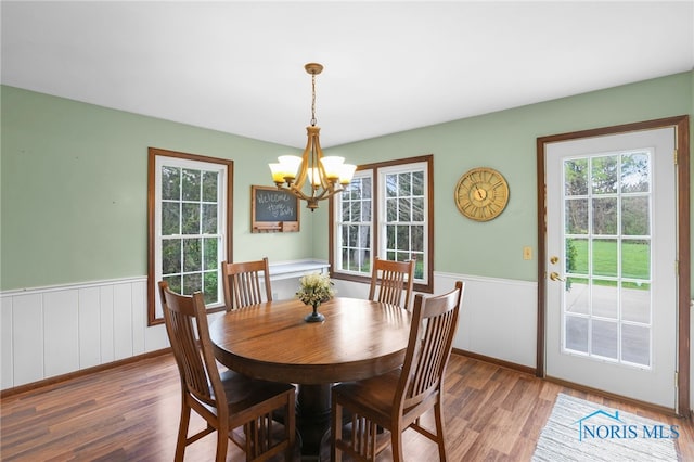 5605 Weckerly Rd, Whitehouse, OH 43571 - dining area featuring wood finished floors, a wainscoted wall, and an inviting chandelier