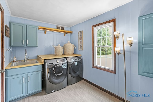 5605 Weckerly Rd, Whitehouse, OH 43571 - clothes washing area with ornamental molding, baseboards, separate washer and dryer, a sink, and cabinet space
