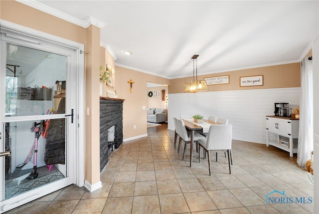 dining area featuring a fireplace, crown molding, and light tile patterned floors