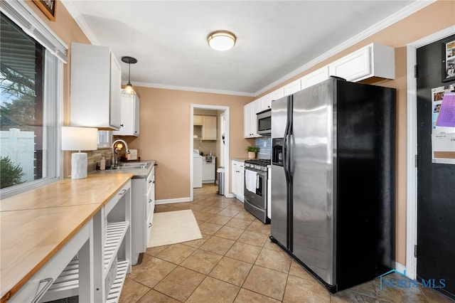 kitchen featuring stainless steel appliances, light countertops, ornamental molding, white cabinets, and a sink