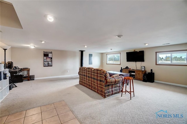 living area with light carpet, a wood stove, and baseboards