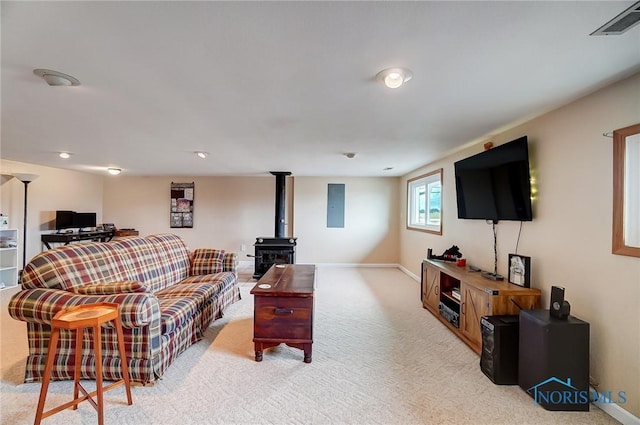 carpeted living area with a wood stove, visible vents, electric panel, and baseboards