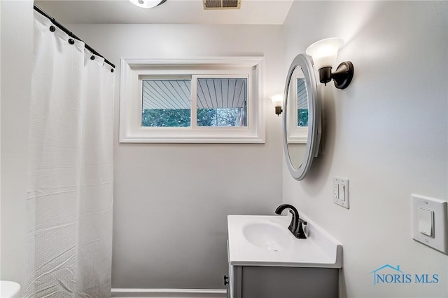 bathroom with a shower with shower curtain, visible vents, and vanity