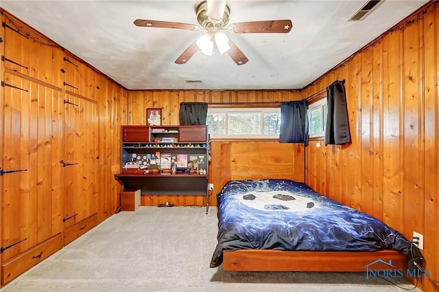 bedroom with wood walls, visible vents, and carpet flooring