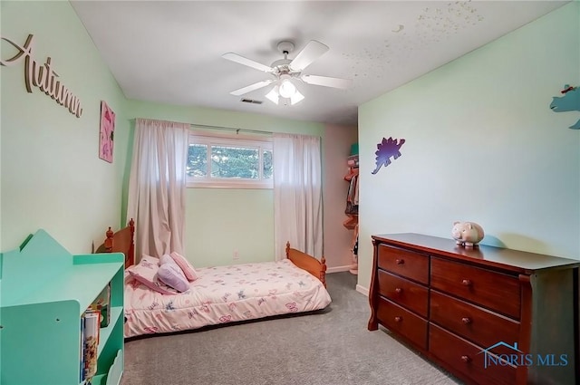 carpeted bedroom featuring a ceiling fan and visible vents