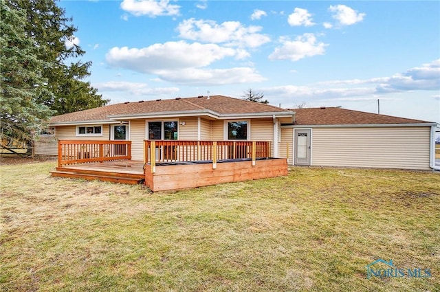 back of house with a deck and a yard