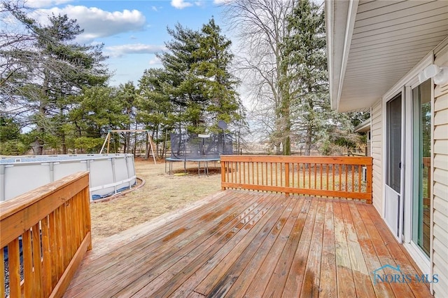 deck with a trampoline and an outdoor pool