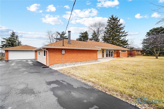 ranch-style home with an outbuilding, brick siding, a chimney, a garage, and a front lawn