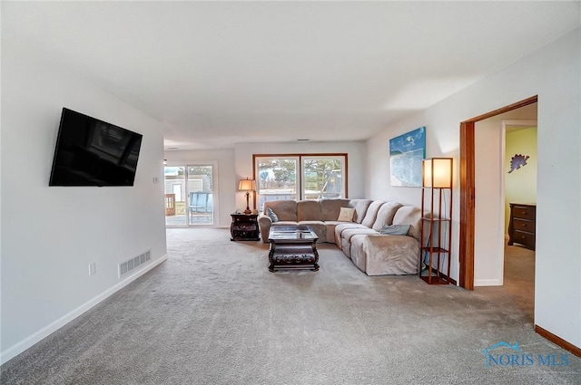 carpeted living room with visible vents and baseboards