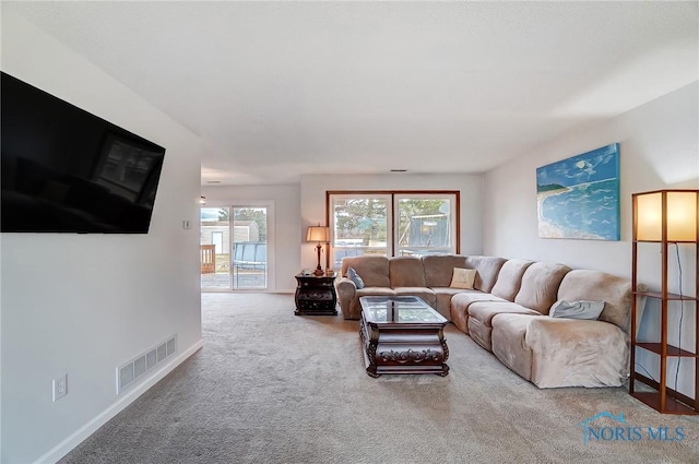 living area with carpet floors, visible vents, and baseboards