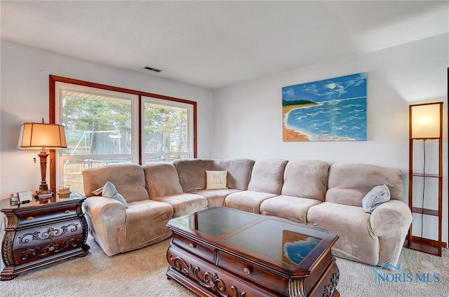 living area featuring carpet floors and visible vents