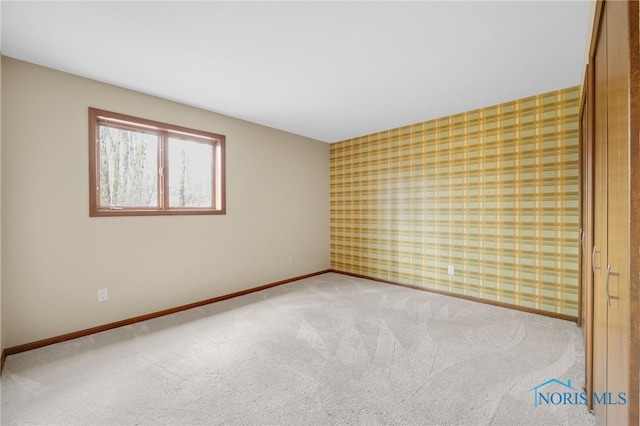 unfurnished room featuring carpet, baseboards, and wallpapered walls