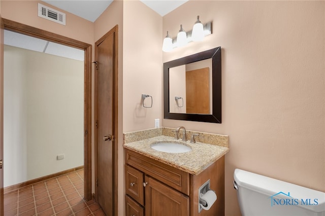 half bathroom with visible vents, vanity, and toilet