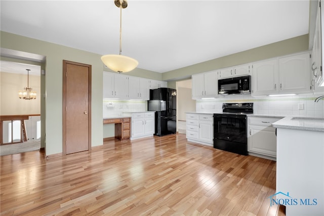 kitchen with black appliances, tasteful backsplash, white cabinets, and a sink