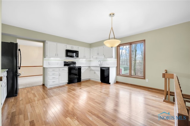 kitchen featuring black appliances, light wood-type flooring, light countertops, and decorative backsplash