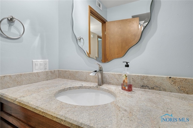 bathroom with vanity and visible vents