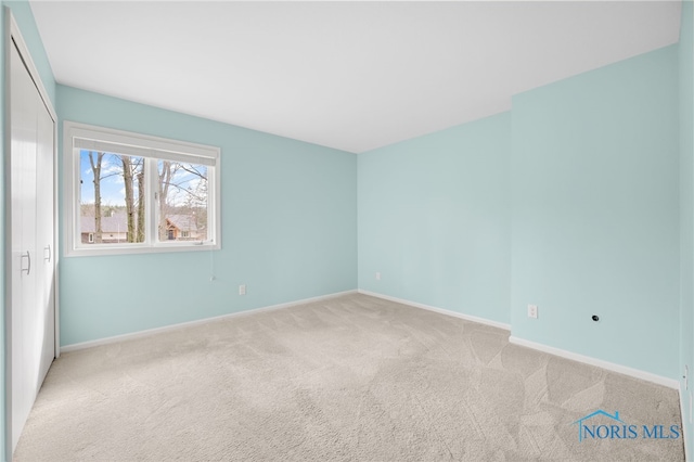 spare room featuring carpet floors and baseboards