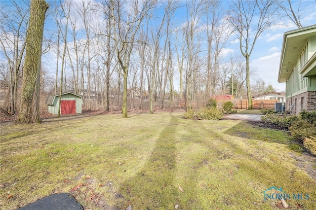 view of yard featuring central AC, fence, an outdoor structure, and a shed