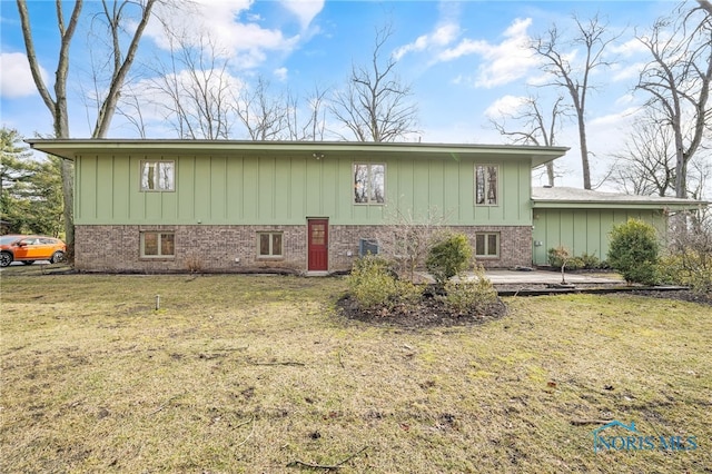 rear view of house with a yard and brick siding